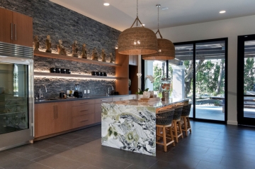 A luxurious kitchen featuring a marble island and a sleek refrigerator, designed for a health spa environment.