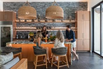 A group of individuals seated at a kitchen island, engaged in a wellness and nutrition coaching session at a detox center.