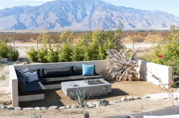 A backyard featuring a fire pit with a mountain backdrop, promoting relaxation at We Care Spa.