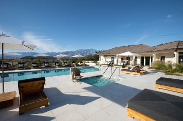 A tranquil pool area at the resort, encircled by stunning mountains, highlights the Luxury Wellness Retreat experience.