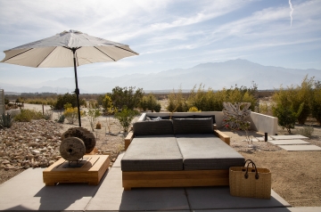 A cozy patio featuring a couch and an umbrella, set for relaxation during the Holistic Body Cleanse 6-day retreat.