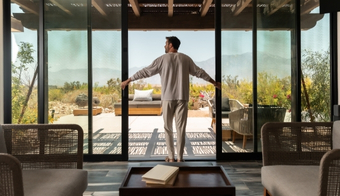 A man stands in front of a sliding glass door at the Colon Cleansing SPA during a 5-night stay.