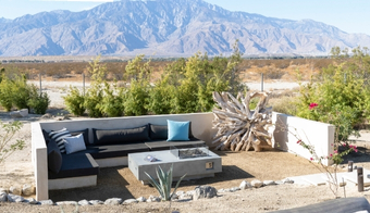 A backyard featuring a fire pit and a couch, promoting a relaxing atmosphere for a 7-night Colon Cleansing SPA stay.