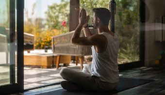A man sits in a yoga pose on a mat at the Holistic Detox Center during a 7-night stay.