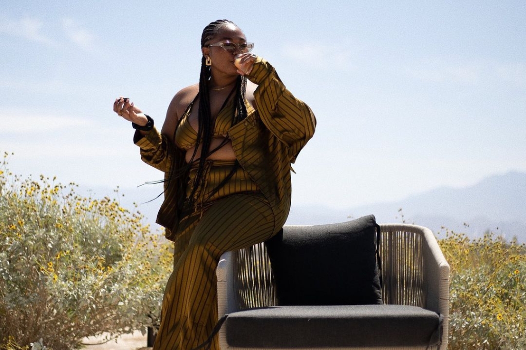 A woman in a gold dress seated on a chair, promoting Liquid Nutrition for Adults.