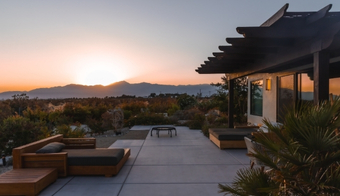 Elegant patio with a sunset and mountain backdrop, advertising a two-night stay at a luxury health spa.