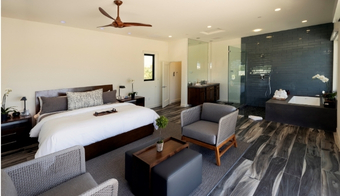 Cozy bedroom with a large bed and a bathroom, showcasing the comfort of a 7-night stay at Wellness Center Palm Springs.