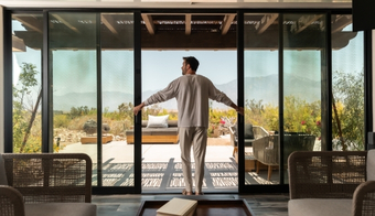Man in a living room near sliding glass doors, showcasing a two-night stay at a rejuvenation spa retreat.