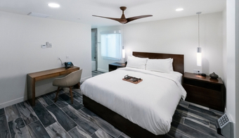 Cozy hotel room with a bed, desk, and ceiling fan, included in a 2-night stay at Colon Hydrotherapy Spa.