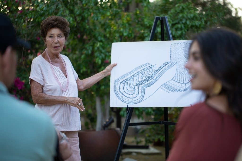 A woman presents to an audience at a Colonic Irrigation Spa, discussing health and wellness topics.