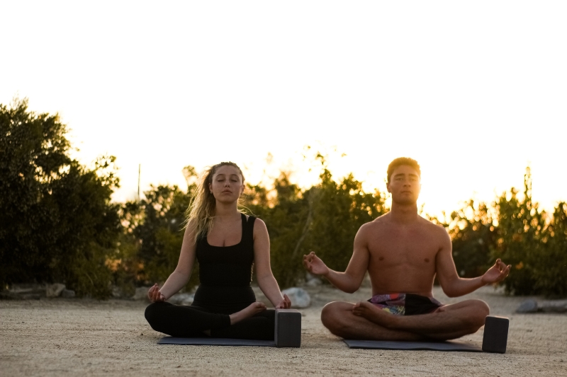 A man and woman practicing yoga together, demonstrating mindful techniques for a detox cleanse.