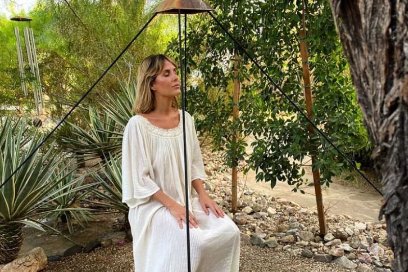 A woman in a flowing white dress enjoys a moment on a peaceful space, considering the mental journey of detoxification.