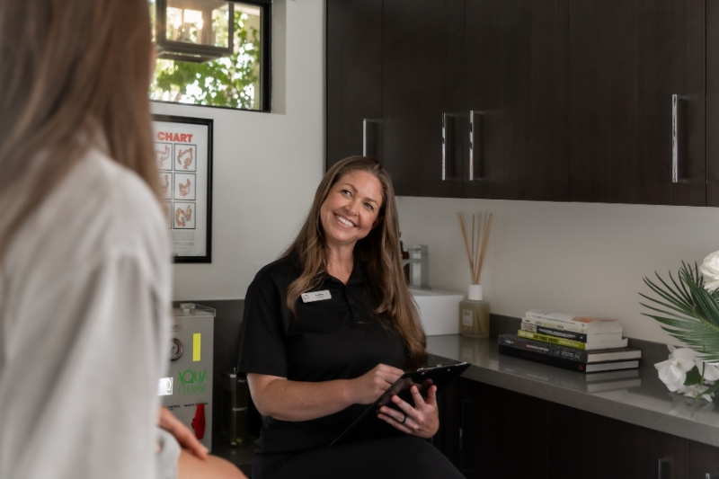 A woman sitting with a clipboard, focused on a 5-day weight loss detox program.