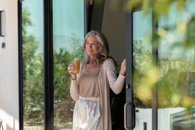 A woman outdoors, holding a glass of wine, representing a moment of leisure in the context of weight loss detox strategies.