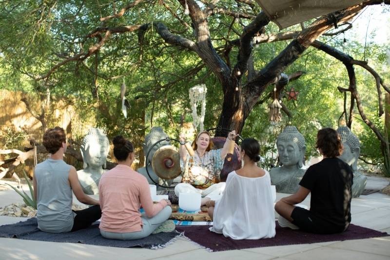 Group sound healing in nature, highlighting peaceful detox retreat environment
