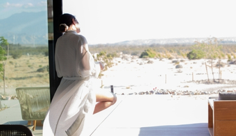 Woman in robe enjoying desert view at 2 night juice cleanse wellness retreat
