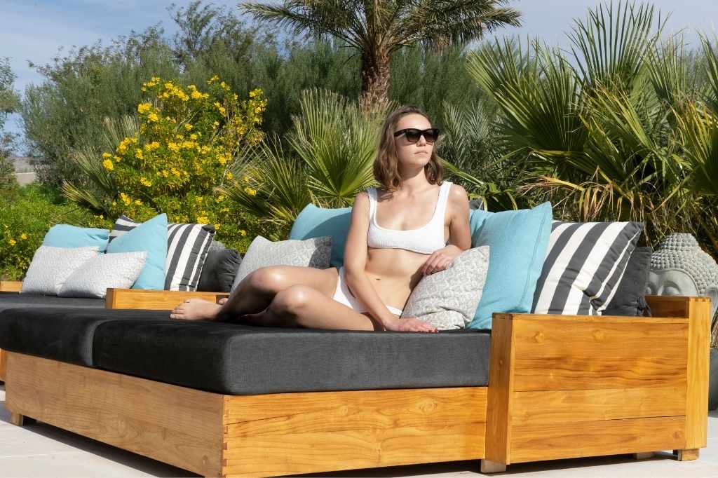 Woman relaxing outdoors during wellness retreat at luxury spa garden lounge area