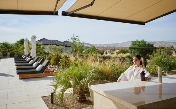 Woman relaxing with detox drink at luxury spa poolside during juice cleanse retreat
