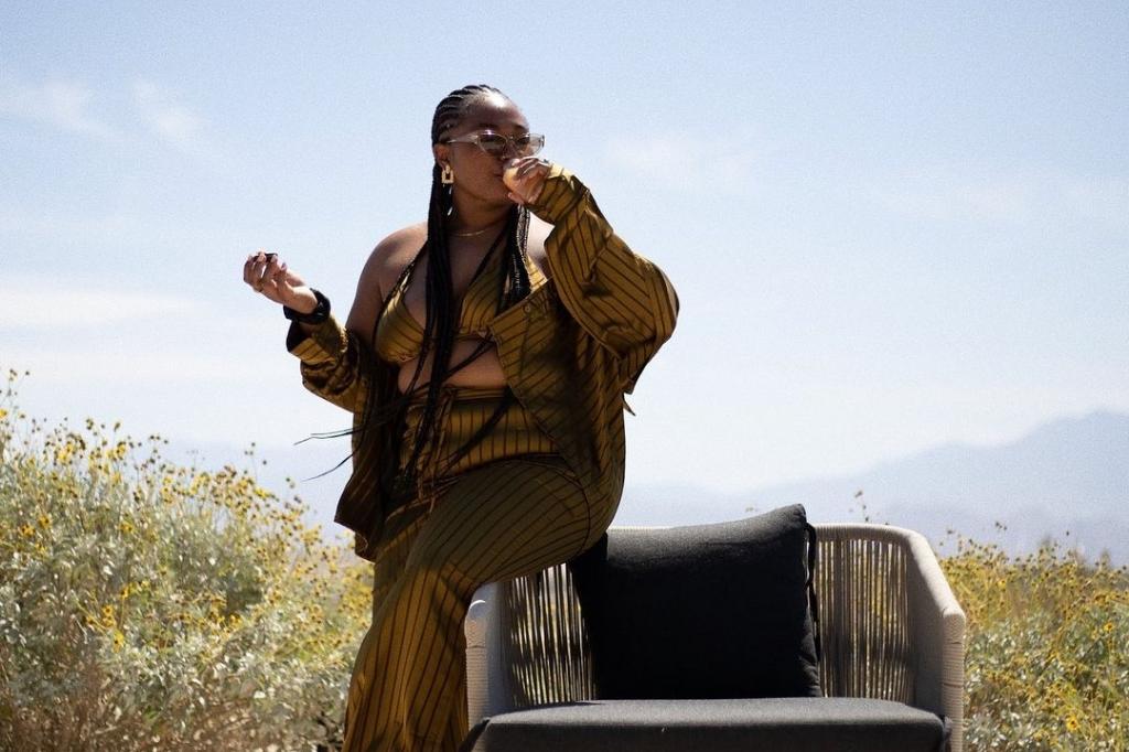 Woman enjoying fresh juice outdoors during liquid nutrition wellness retreat at spa