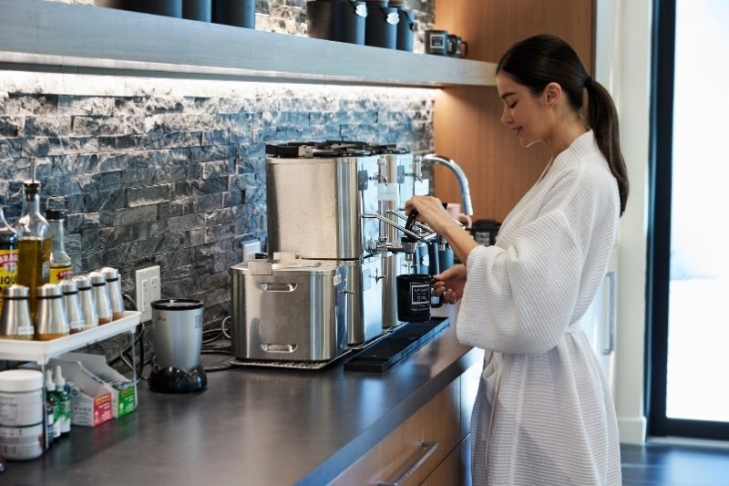 A wellness guest prepares a nourishing beverage as part of a healthy detox and whole-food lifestyle routine.