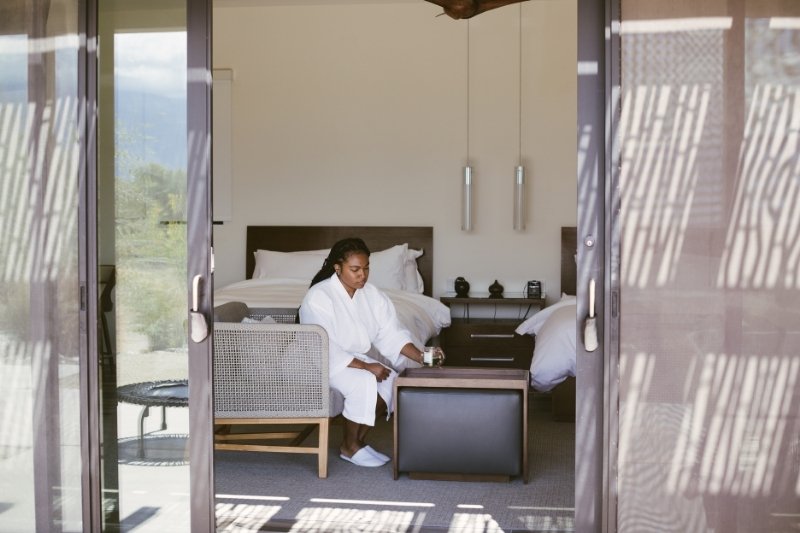 A spa guest enjoys a quiet moment indoors while focusing on rest, recovery, and holistic wellness.