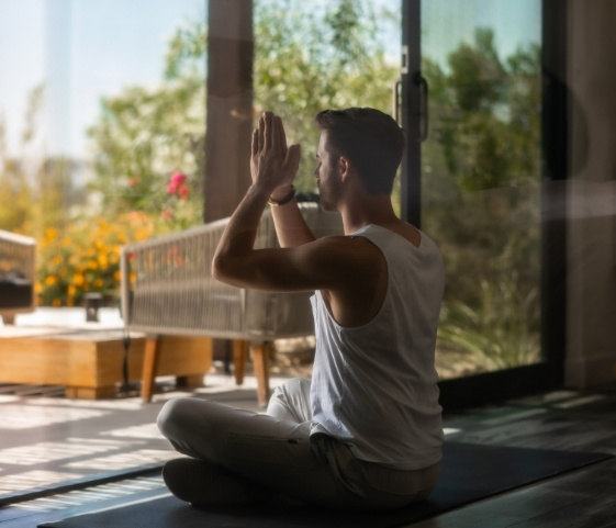 Man meditating indoors at Palm Springs wellness resort with peaceful garden view