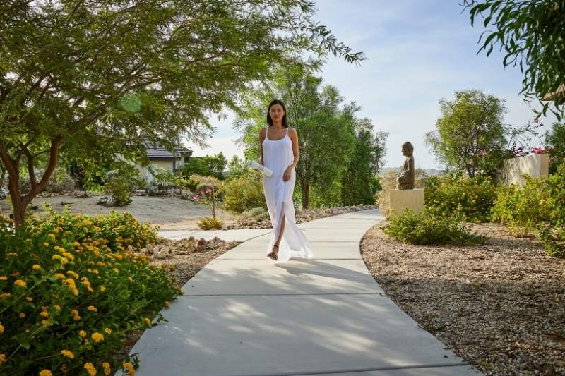 A wellness guest enjoys a tranquil walk through nature during a personalized detox retreat experience.