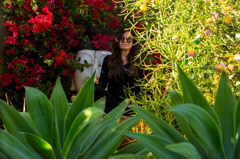 Woman meditating in a tranquil garden to enhance mental clarity and energy during menopause