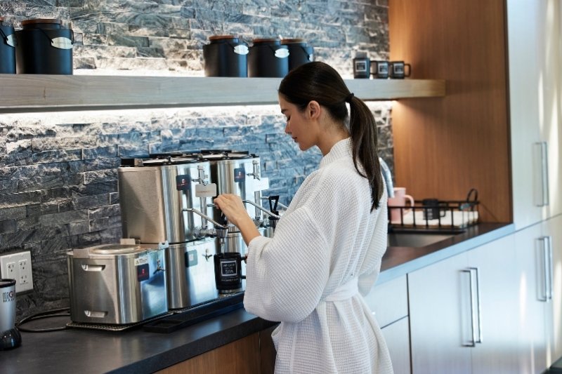 Woman preparing herbal tea as part of a gradual fasting program for menopause wellness