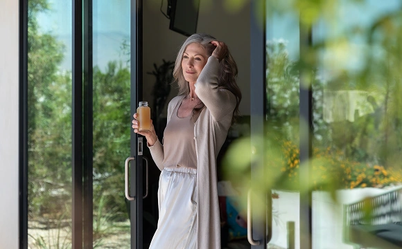 Guest enjoys a wellness drink and quiet moment during her stay at We Care Spa