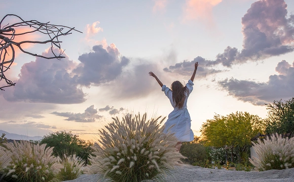 Guest embraces the peaceful desert setting and mountain views at We Care Spa