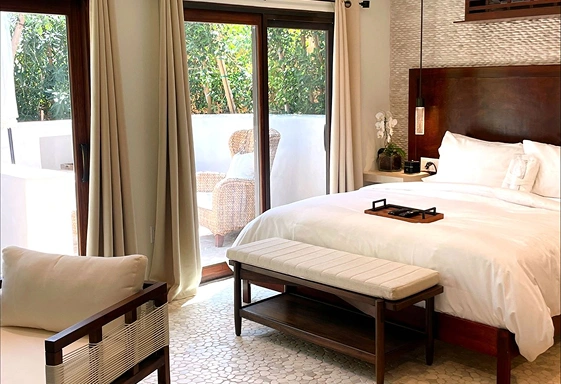 Club Suite bedroom with private patio and garden views at We Care Spa