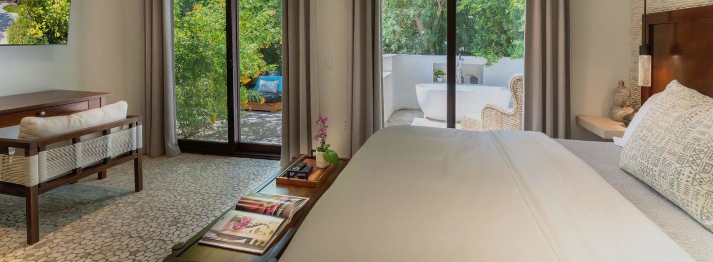 Club Suite bedroom with private patio and outdoor soaking tub at We Care Spa