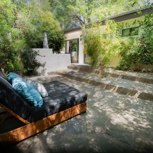 Club Suite private patio with lounge seating and lush gardens at We Care Spa