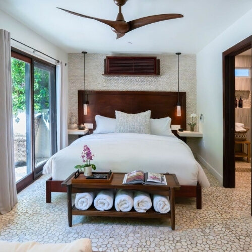 Club Suite bedroom with plush bedding and garden patio at We Care Spa