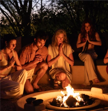 Guests gathering for a peaceful fire ceremony at We Care Spa’s detox retreat.