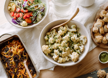 Healthy meal preparation with fresh vegetables, cauliflower, and plant-based dishes at We Care Spa.