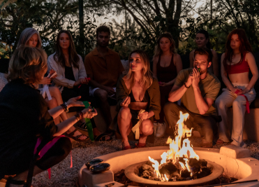 Group shamanic blessing ceremony around a fire at We Care Spa’s wellness retreat.