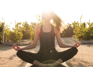 Woman practicing meditation at sunrise during a holistic wellness retreat at We Care Spa.