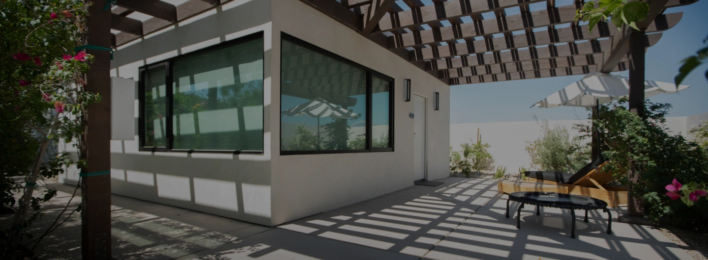 Premier Suite private patio with shaded lounge area and garden views at We Care Spa.